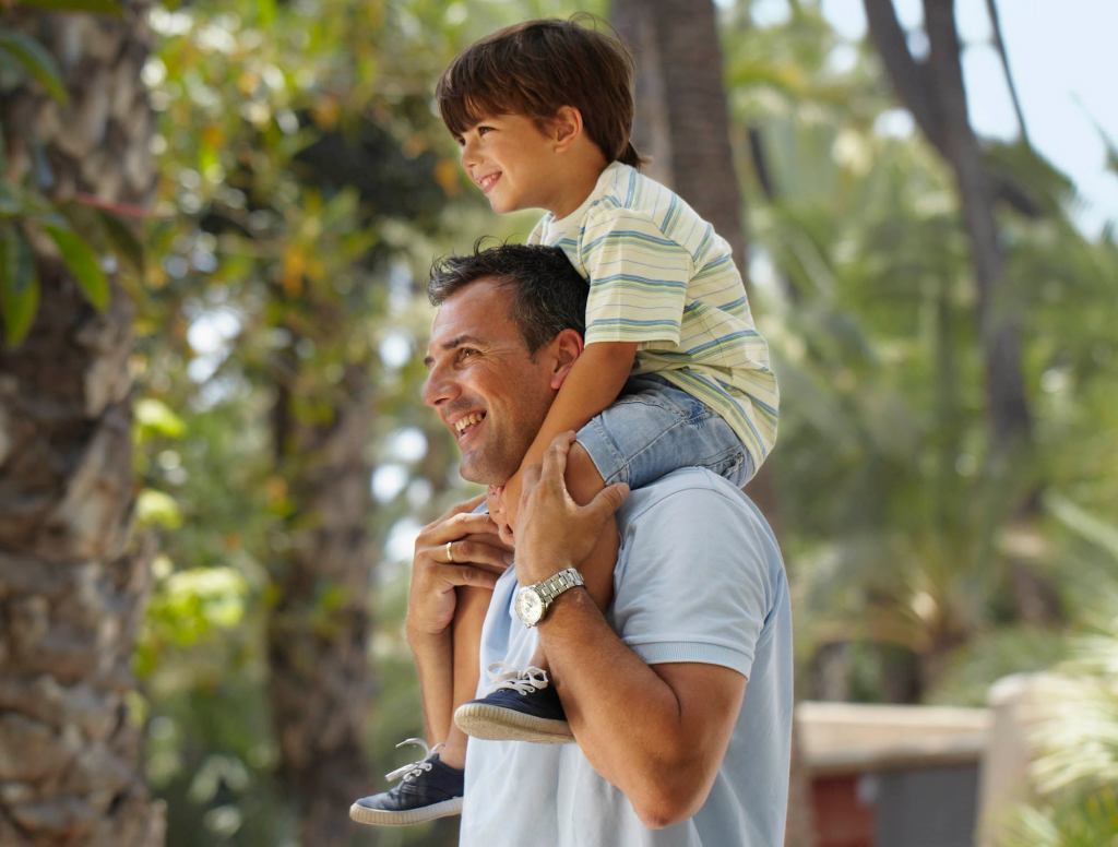 Child Boosted On Shoulders For Better View Of Man Having Heart Attack