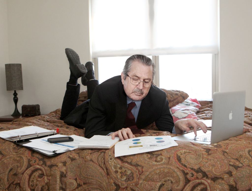 Businessman Does His Work Lying On Bed Like Schoolgirl