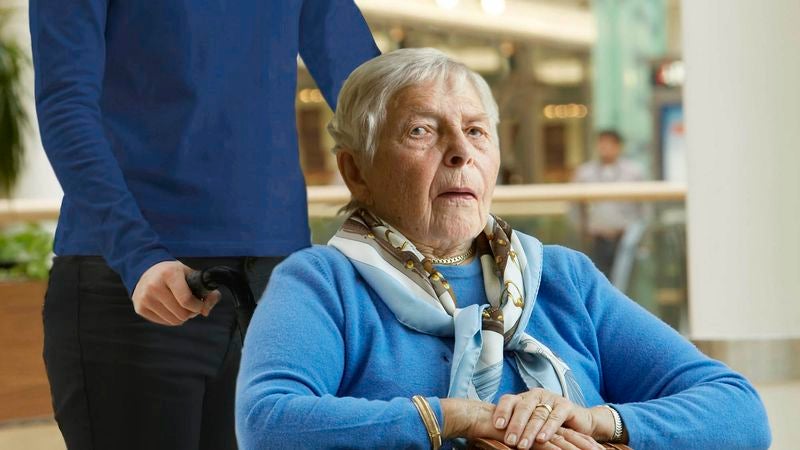 Lucky Old Woman Getting Wheeled Around Airport