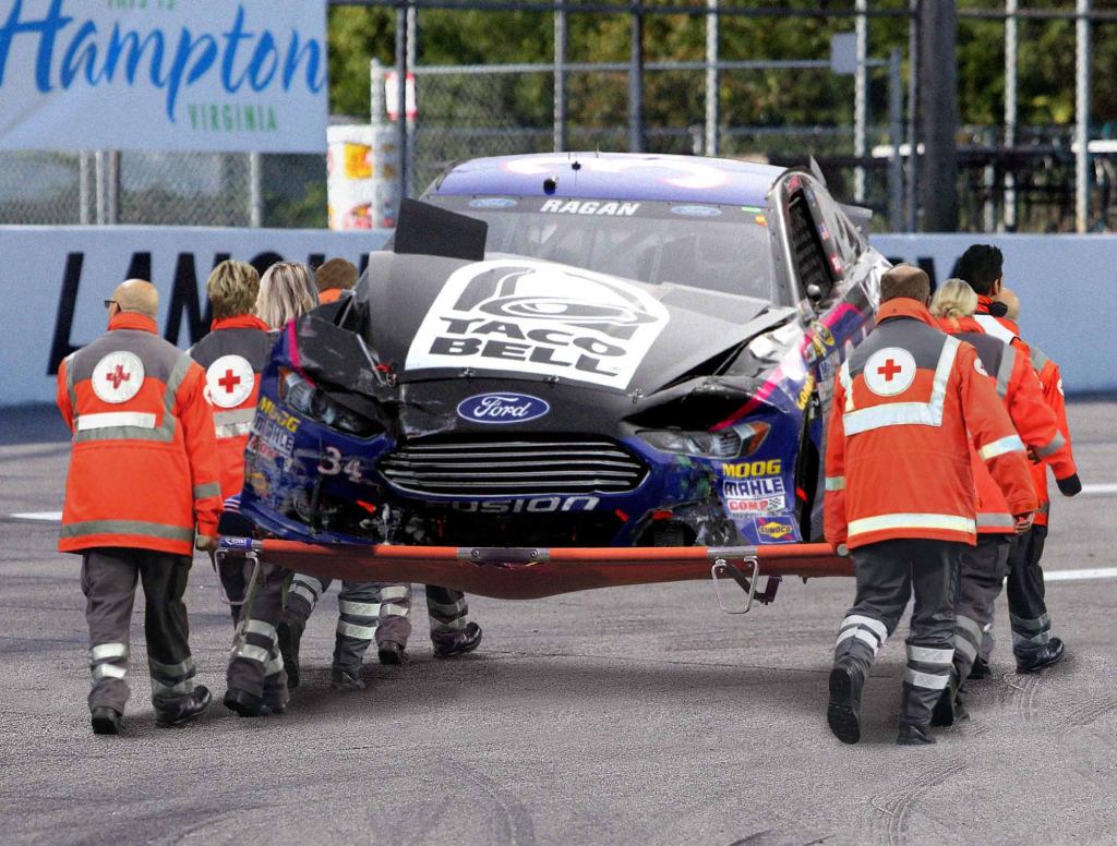 Badly Damaged Race Car Carried Off Track On Stretcher