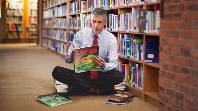 Arne Duncan Spends Visit To Local Elementary School Looking At UFO Books In Library