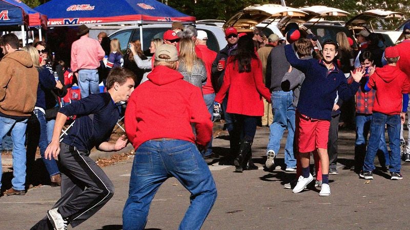 Tailgaters Playing Sad Little Game Of Pickup Football In Stadium Parking Lot