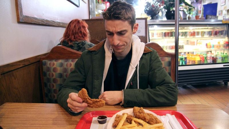 Man Searching For Part Of Chicken Tender Thin Enough To Fit Into Plastic Dipping Sauce Cup