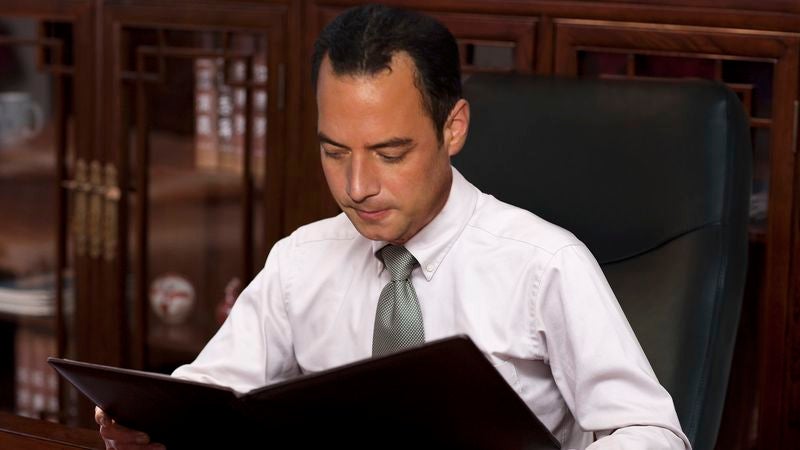 Reince Priebus Smiles, Shakes Head While Flipping Through Old Briefing On GOP’s Plans For 2016