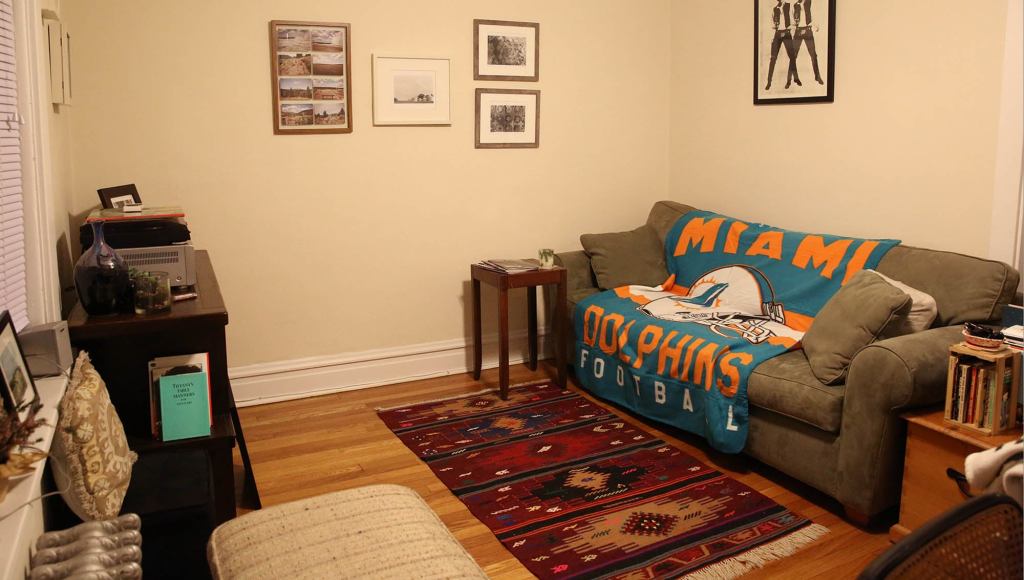 Carefully Thought-Out Living Room Decor Overshadowed By Enormous Blanket With Team Logo On It