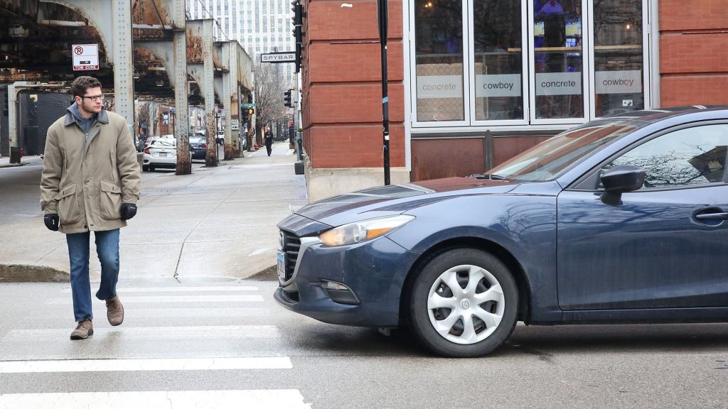 Pedestrian Crossing Street Makes Sure To Look At Approaching Car So Driver Will Feel More Guilty If They Run Him Over