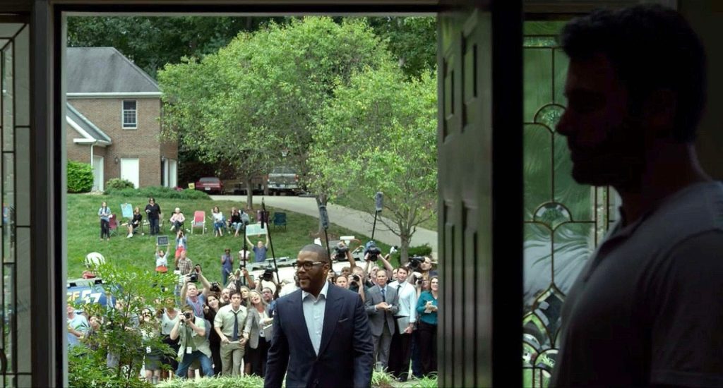 Character In Thriller Film Totally Unaware 100 Reporters On Front Lawn Until He Opens Door