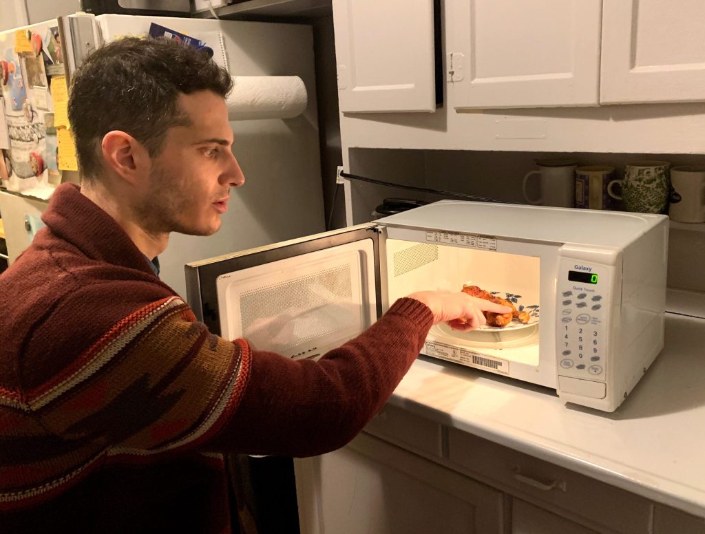 Man Checking If Chicken Wings Got Hot Enough In Microwave Like First Responder Searching For Pulse