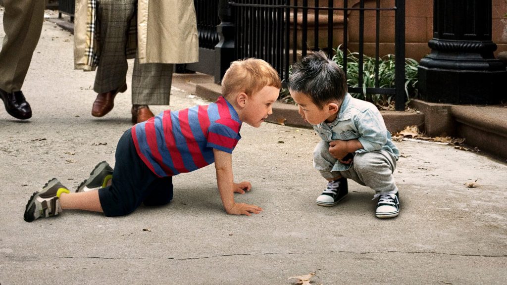 Pedestrians Passing Each Other On Sidewalk Stop To Let Children Sniff Each Other