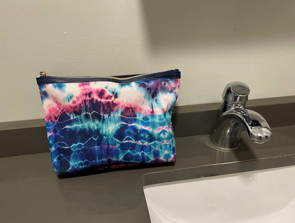 Friend On Group Trip Establishes Dominance By Placing Toiletry Bag On Bathroom Counter