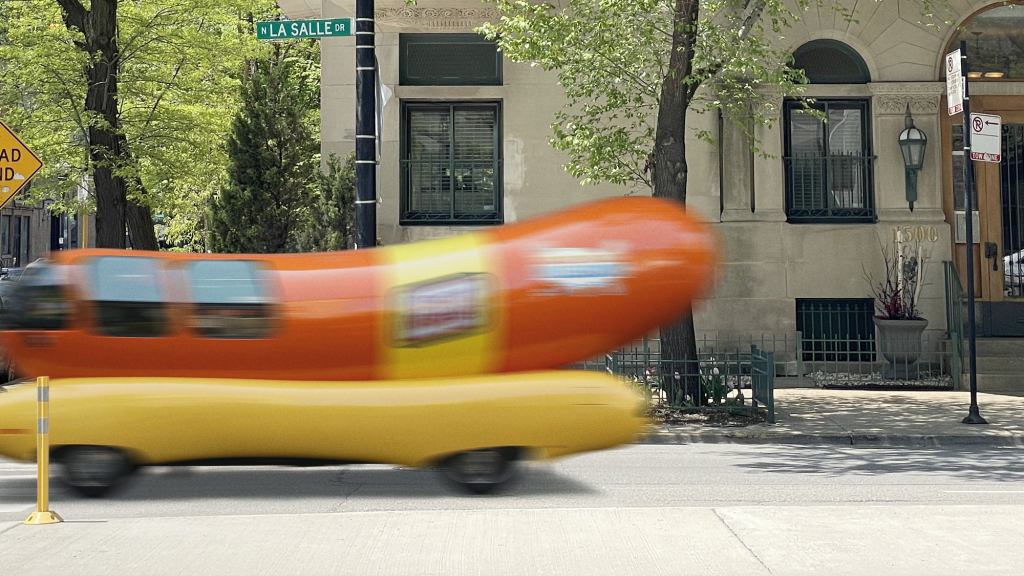 Mysterious Figure Impossibly Disappears Behind Passing Wienermobile