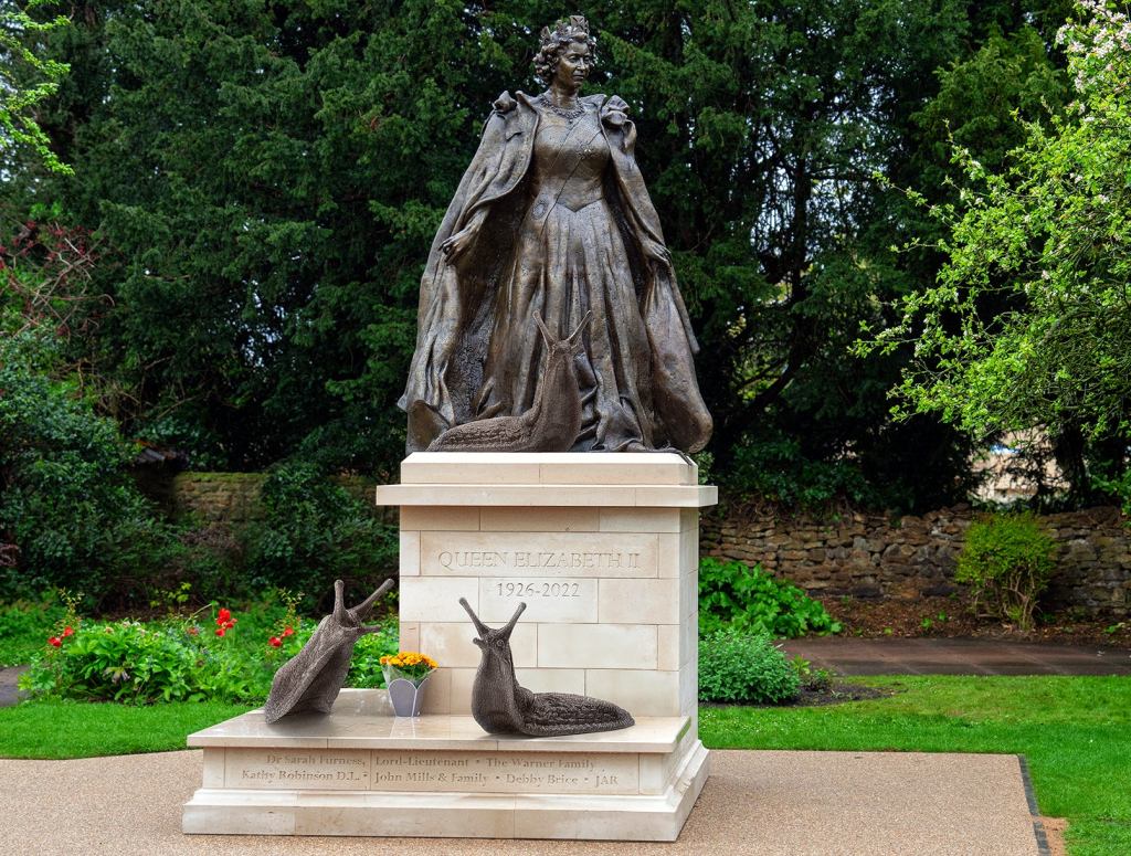 British Sculptor Unveils Memorial Statue Of Queen Elizabeth Surrounded By Her Beloved Slugs